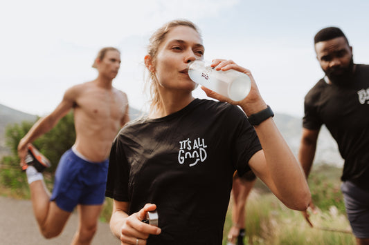 Girl on table mountain drinking amino plus, an essential amino acid and electrolyte blend meant to improve muscle protein synthesis and help with endurance and resistance training